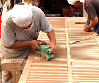 木製の雨戸を塗装が定着しやすいように下地処理を施している様子です。お客様が自作された雨戸を手作業で優しく処理いたしました。