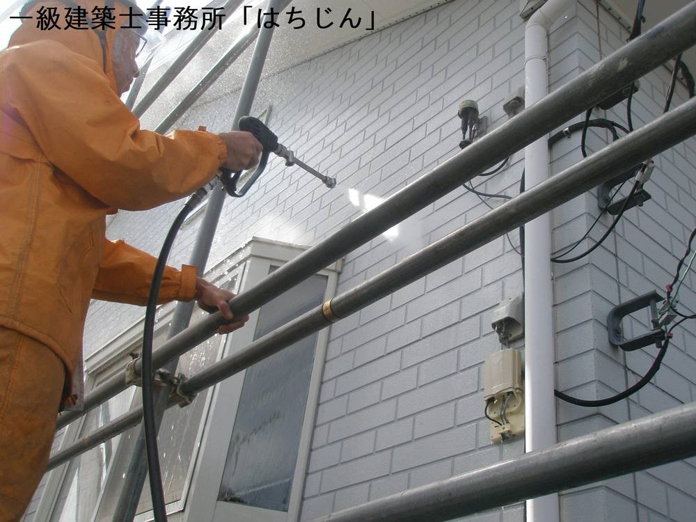 高圧洗浄機で外壁と屋根の汚れを落としている様子