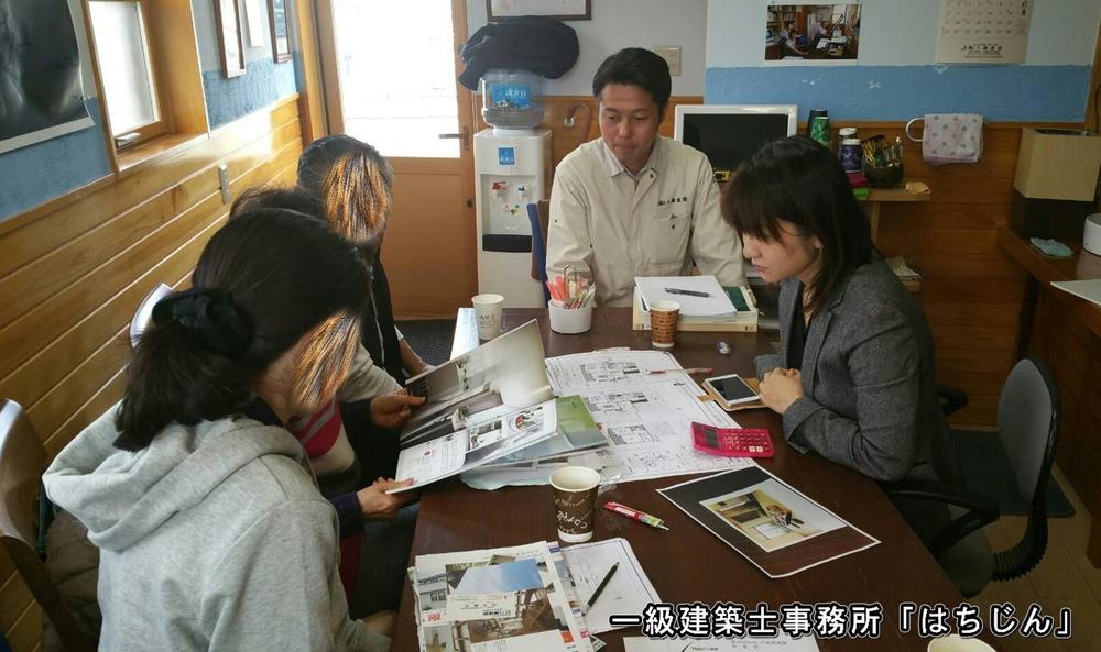 図面とカタログを広げてお客様と打ち合わせをしている様子